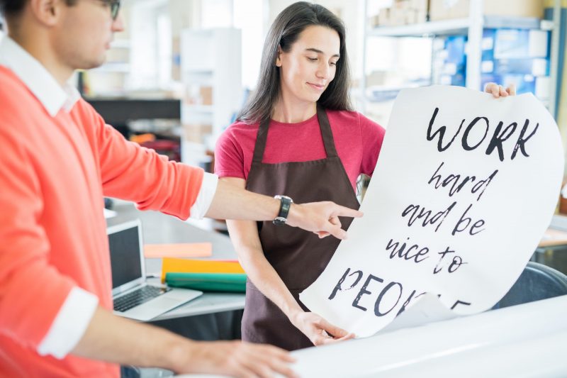 Coworking colleagues with printed poster