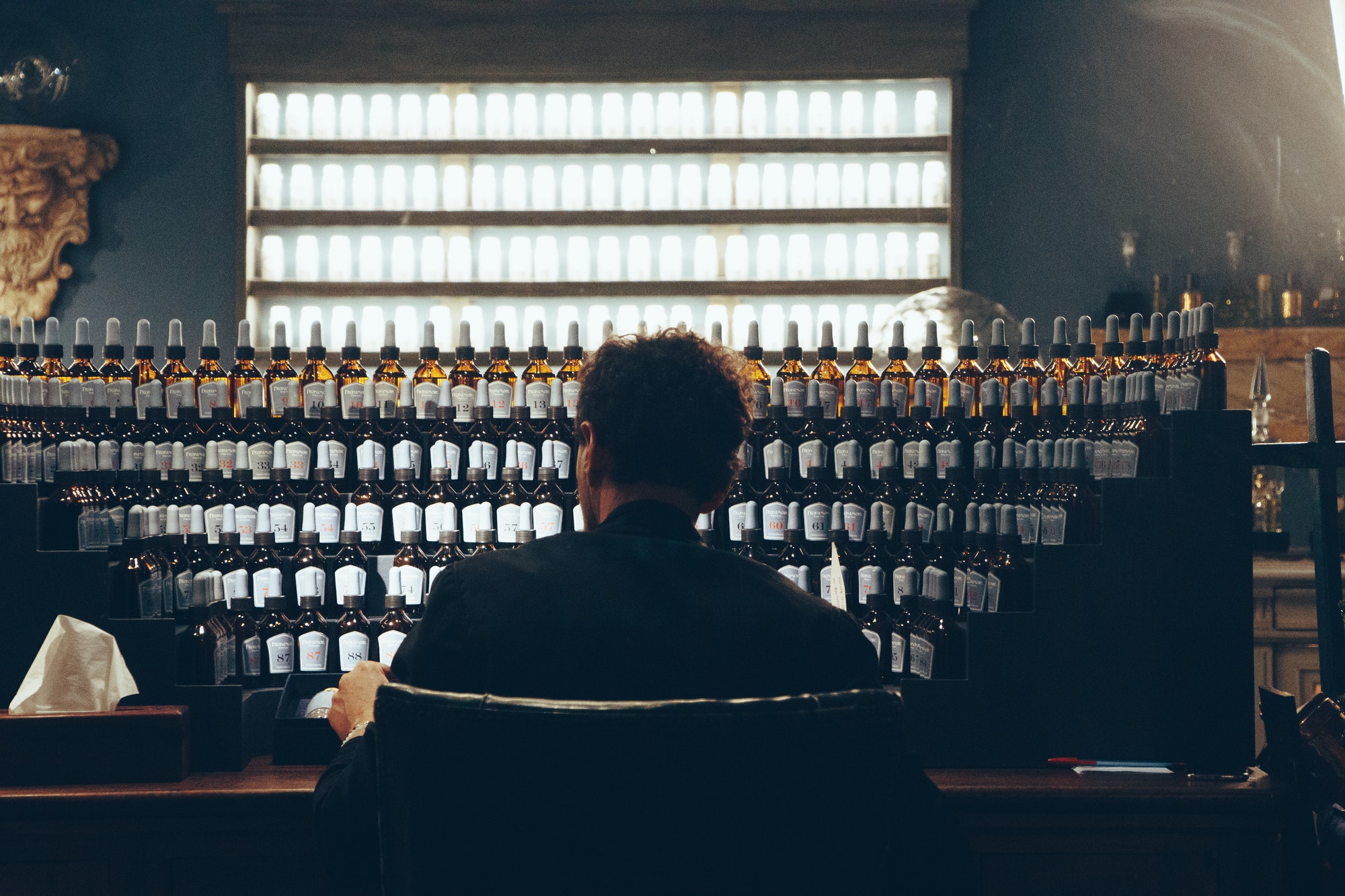 Perfume Master designing a new perfume. Pattern of small bottles.